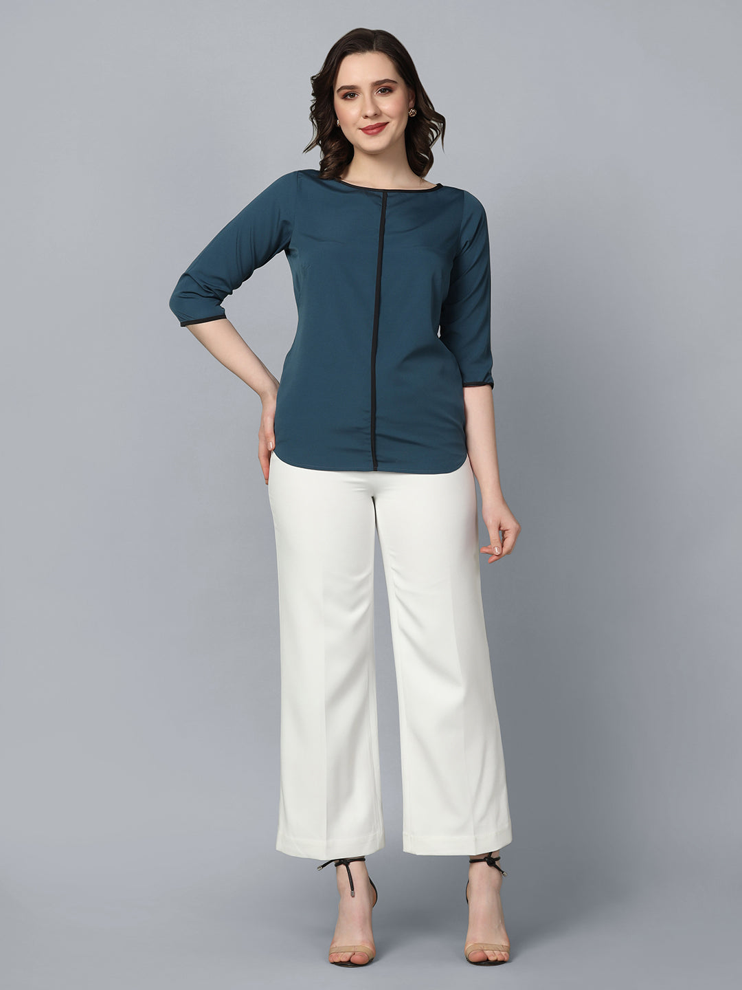 Boat neck crepe top in teal blue, styled with white pants.